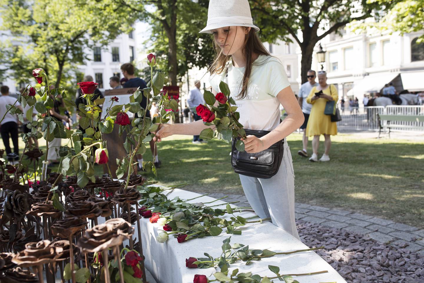 Anastasia Hage (11,snart 12år) legger ned roser ved minnesMerket utenfor Domkirken. 22.juli 2021