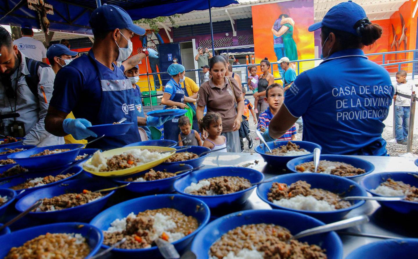 FÅR MAT: Venezuelanske migranter i Colombia ved grensen til Venezuela får servert mat. 	FOTO: NTB SCANPIX