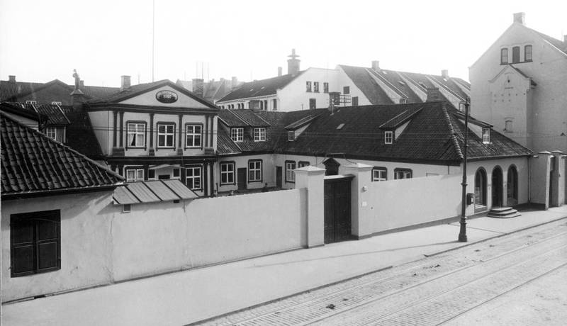 Arbeidsanstalten Prinds Christian Augusts Minde sett fra Storgata i 1914. I midten er den hesteskoforma barokkvillaen Mangelsgården. Til høyre institusjonens kommunale utsalg. I bakgrunnen ligger Fabrikkbygningen fra 1833 og Vaskeribygningen fra 1856 ut mot gata.