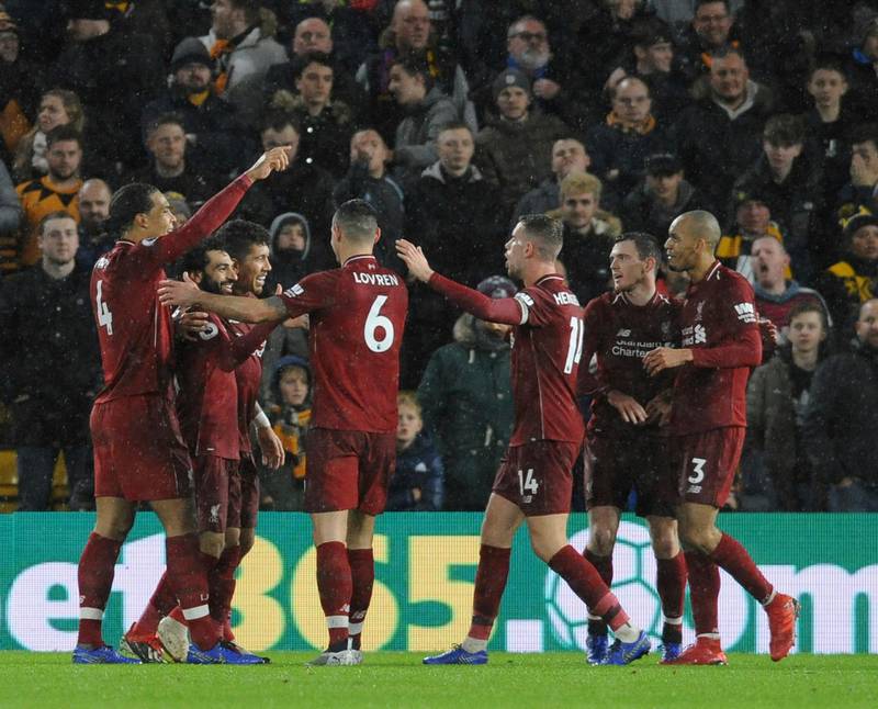 Liverpool's Mohamed Salah, second left, celebrates with his teammates after scoring his side's opening goal during the English Premier League soccer match between Wolverhampton Wanderers and Liverpool at the Molineux Stadium in Wolverhampton, England, Friday, Dec. 21, 2018. (AP Photo/Rui Vieira)