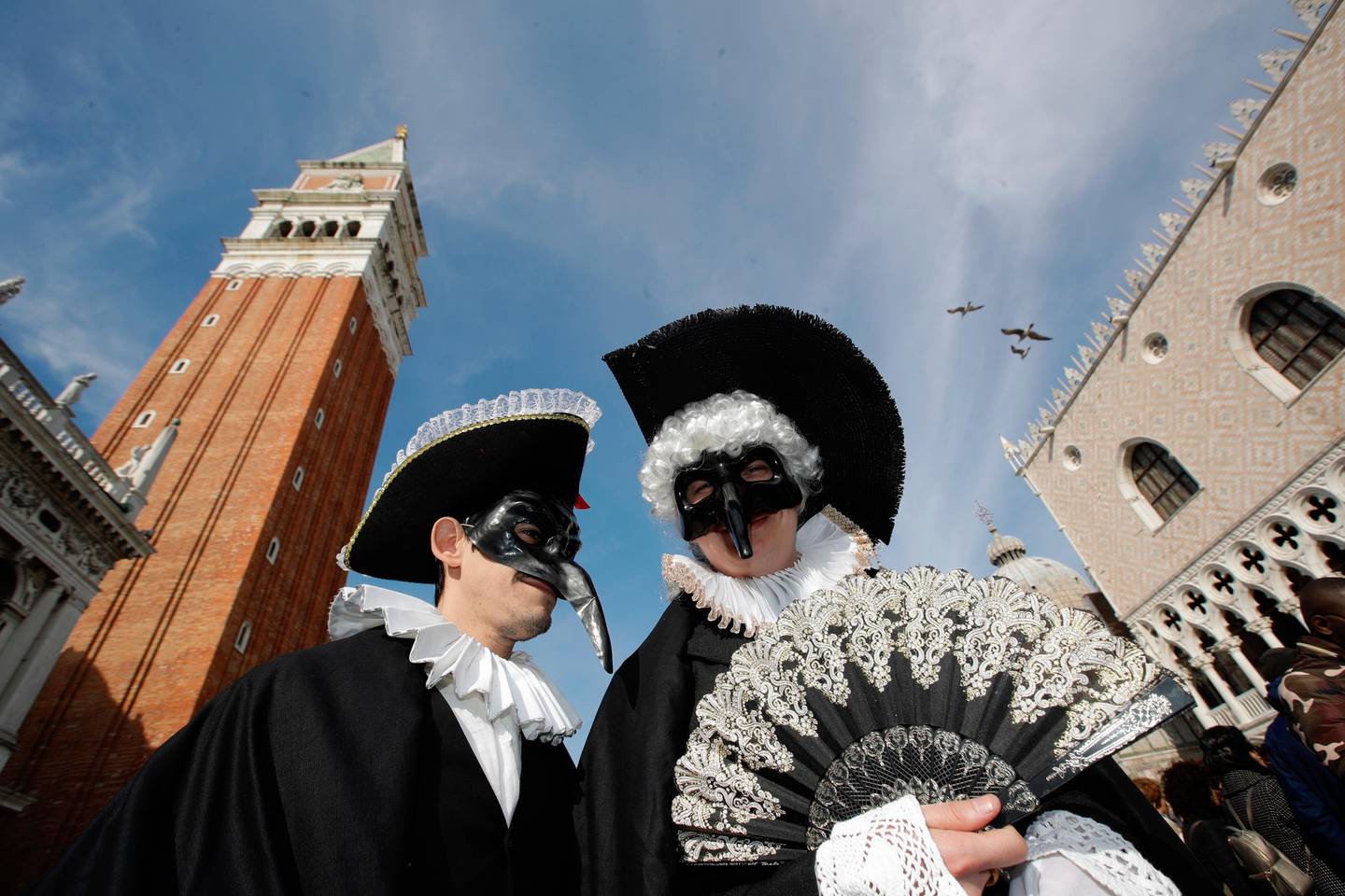People wearing carnival costumes and masks gather in St. Mark's Square during carnival celebrations in Venice, Italy, Sunday, Feb.16, 2020. The Venice carnival in the historical lagoon city attracts people from around the world. (AP Photo/ Luca Bruno)