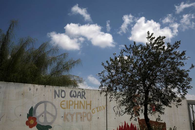«Fred på Kypros» står det på veggen. Det kan skje innen året er omme, ifølge FNs spesialutsending og fredsmegler Espen Barth Eide. FOTO: YIANNIS KOURTOGLOU/NTB SCANPIX
