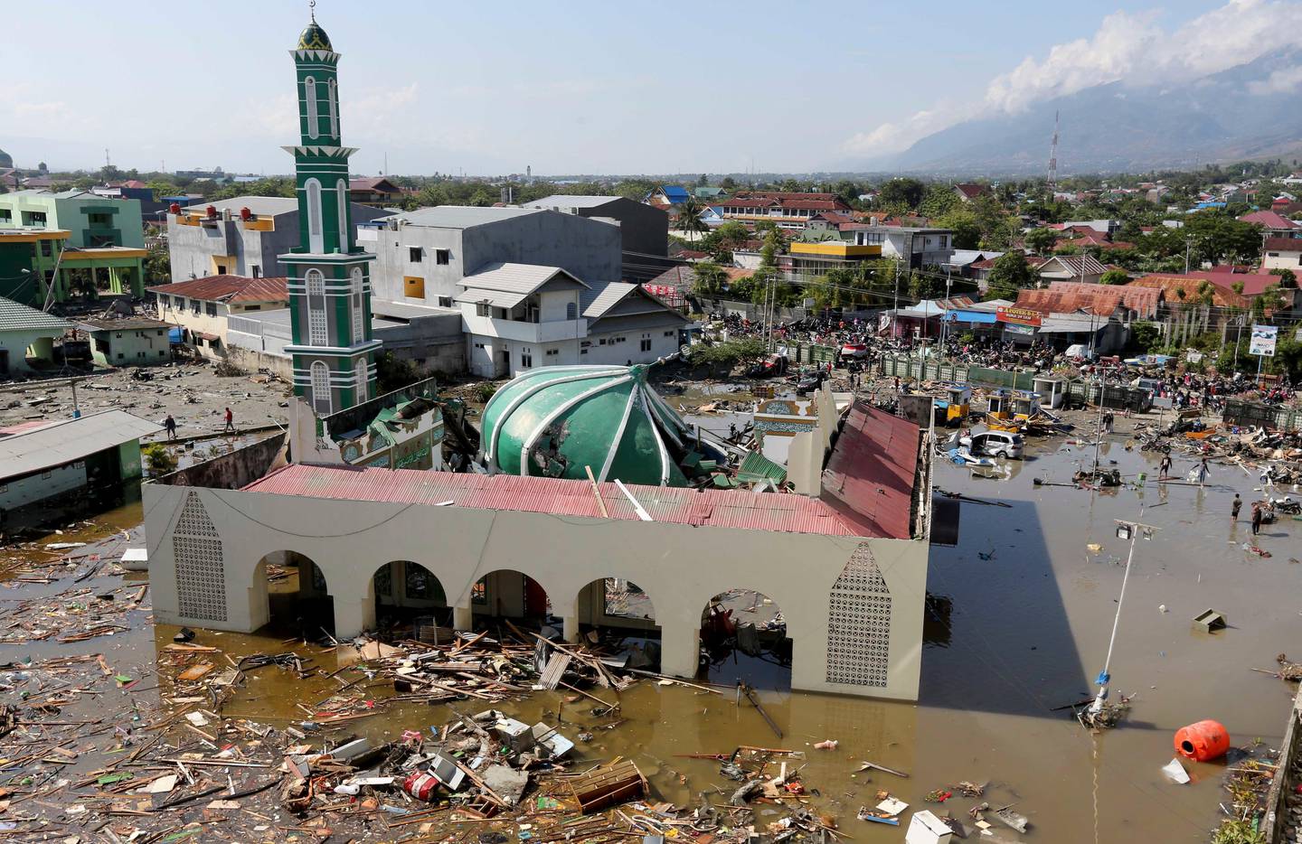 People survey the mosque damaged following earthquakes and tsunami in Palu, Central Sulawesi, Indonesia, Sunday, Sept. 30, 2018. A tsunami swept away buildings and killed hundreds on the Indonesian island of Sulawesi.(AP Photo/Tatan Syuflana)