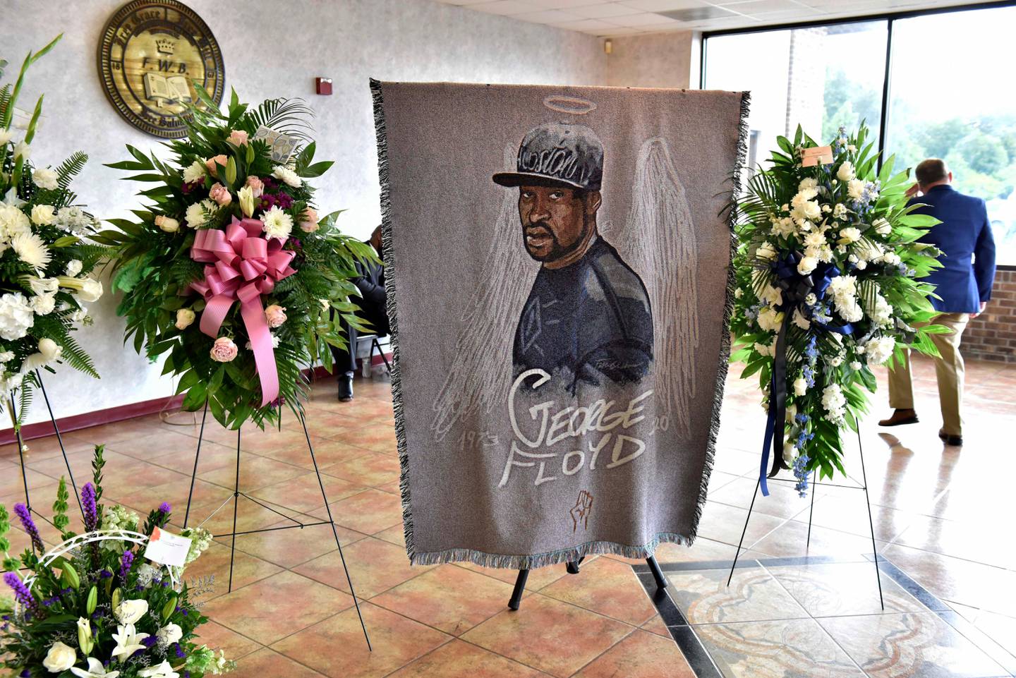 A picture of George Floyd and flowers are set up for a memorial service for Floyd, Saturday, June 6, 2020, in Raeford, N.C. Floyd died after being restrained by Minneapolis police officers on May 25.  (Ed Clemente/The Fayetteville Observer via AP, Pool)