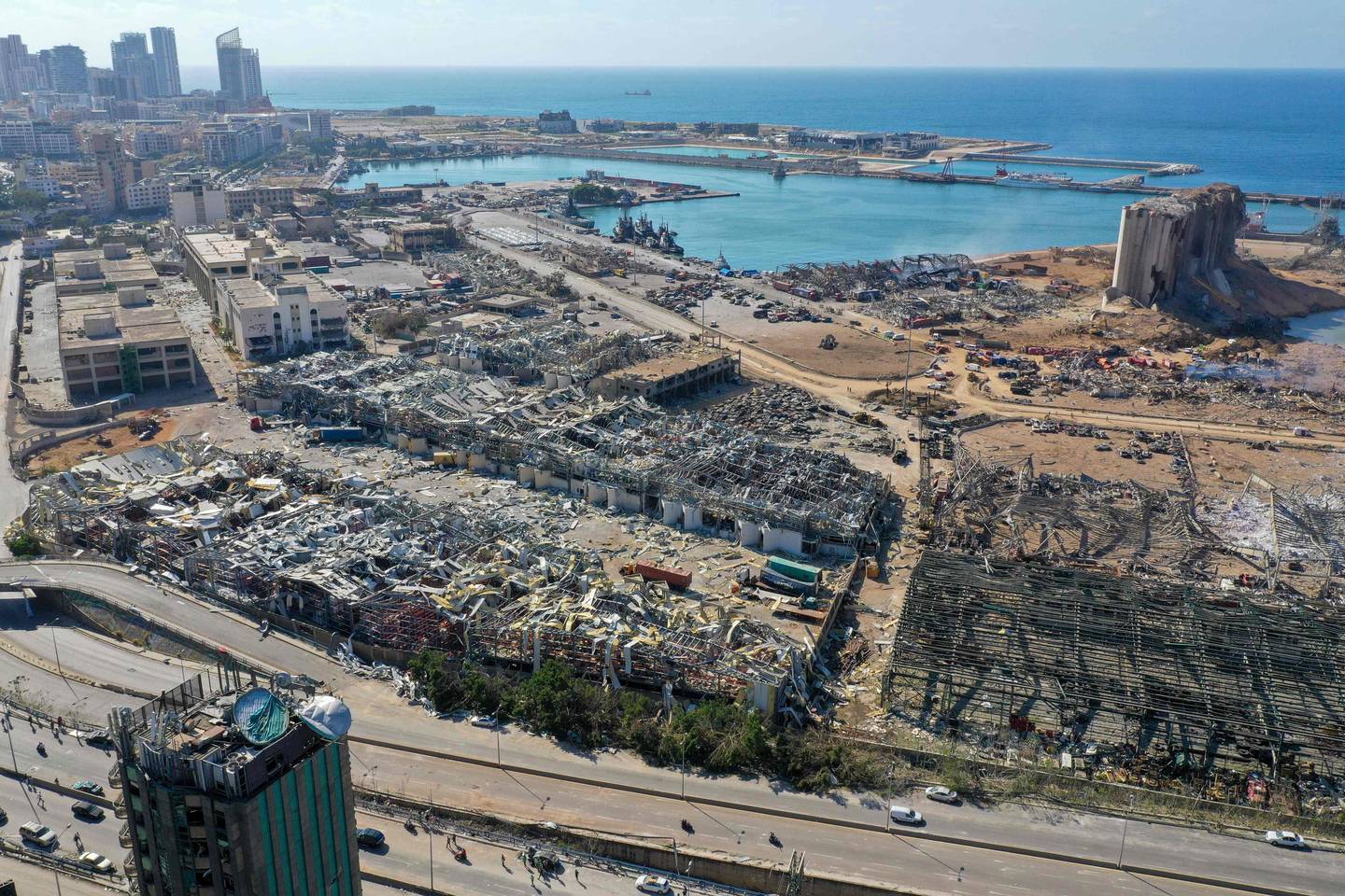 TOPSHOT - An aerial view shows the massive damage done to Beirut port's grain silos (C) and the area around it on August 5, 2020, one day after a mega-blast tore through the harbour in the heart of the Lebanese capital with the force of an earthquake, killing more than 100 people and injuring over 4,000. - Rescuers searched for survivors in Beirut in the morning after a cataclysmic explosion at the port sowed devastation across entire neighbourhoods, killing more than 100 people, wounding thousands and plunging Lebanon deeper into crisis. (Photo by - / AFP)