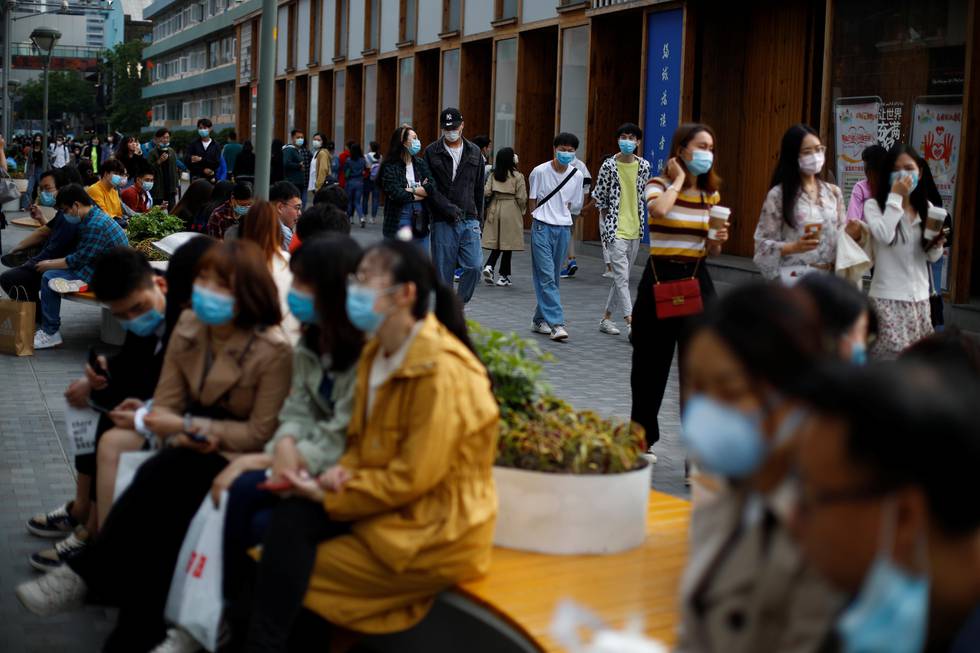 People wearing face masks walk at a shopping street, following the coronavirus disease (COVID-19) outbreak, in Beijing, China May 4, 2020.  REUTERS/Thomas Peter