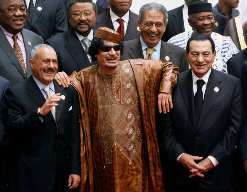 FILE - In this Oct. 10, 2010 file photo, Libyan leader Moammar Gadhafi, center, with Egyptian President Hosni Mubarak, right, and his Yemeni counterpart Ali Abdullah Saleh, left, pose during a group picture with Arab and African leaders during the second Afro-Arab summit in Sirte, Libya. In 2011, an uprising in Tunisia opened the way for a wave of popular revolts against authoritarian rulers across the Middle East known as the Arab Spring. For a brief window as leaders fell, it seemed the move toward greater democracy was irreversible. Instead, the region saw its most destructive decade of the modern era. (AP Photo/Amr Nabil, File)