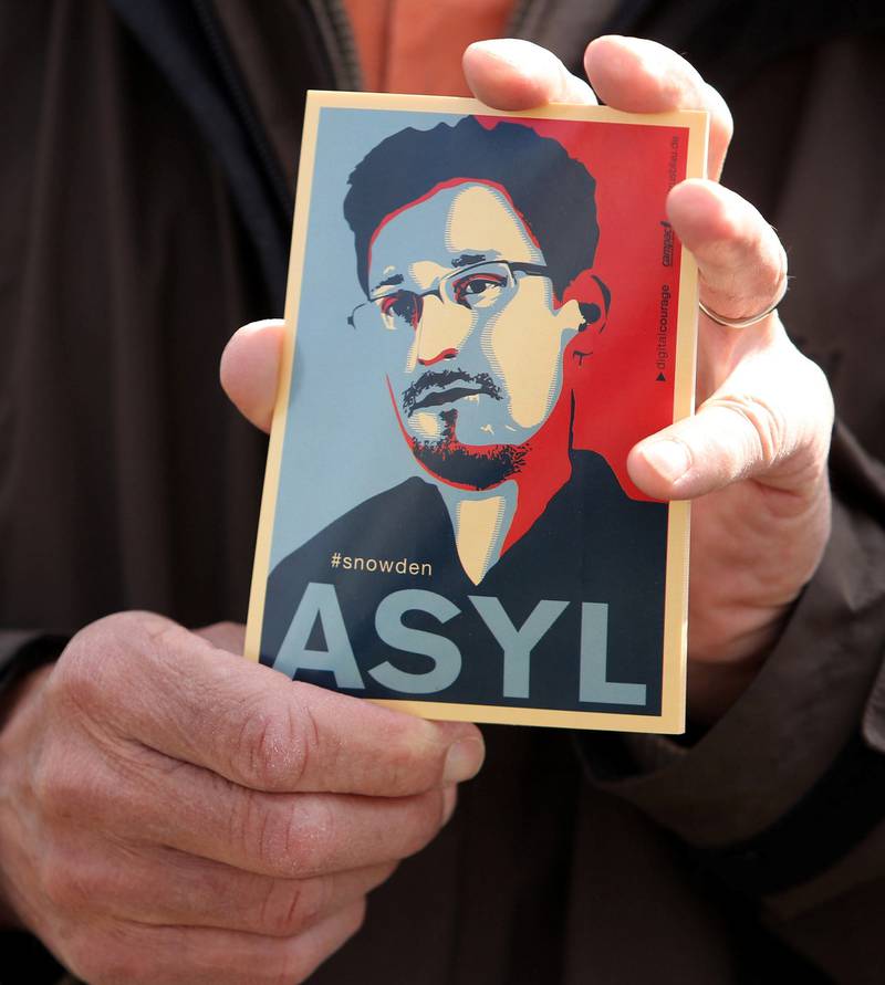 En mann holder et bilde av Edward Snowden i forbindelse med at han avga forklaring på avlyttingen av EU-borgere til EU-parlamentet.