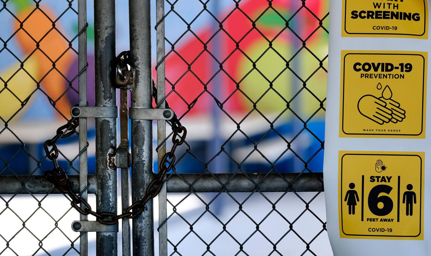 A chain-link fence lock is seen on a gate at a closed Ranchito Elementary School in the San Fernando Valley section of Los Angeles on Monday, July 13, 2020. Amid spiking coronavirus cases, Los Angeles Unified School District campuses will remain closed when classes resume in August, Superintendent Austin Beutner said Monday. (AP Photo/Richard Vogel)