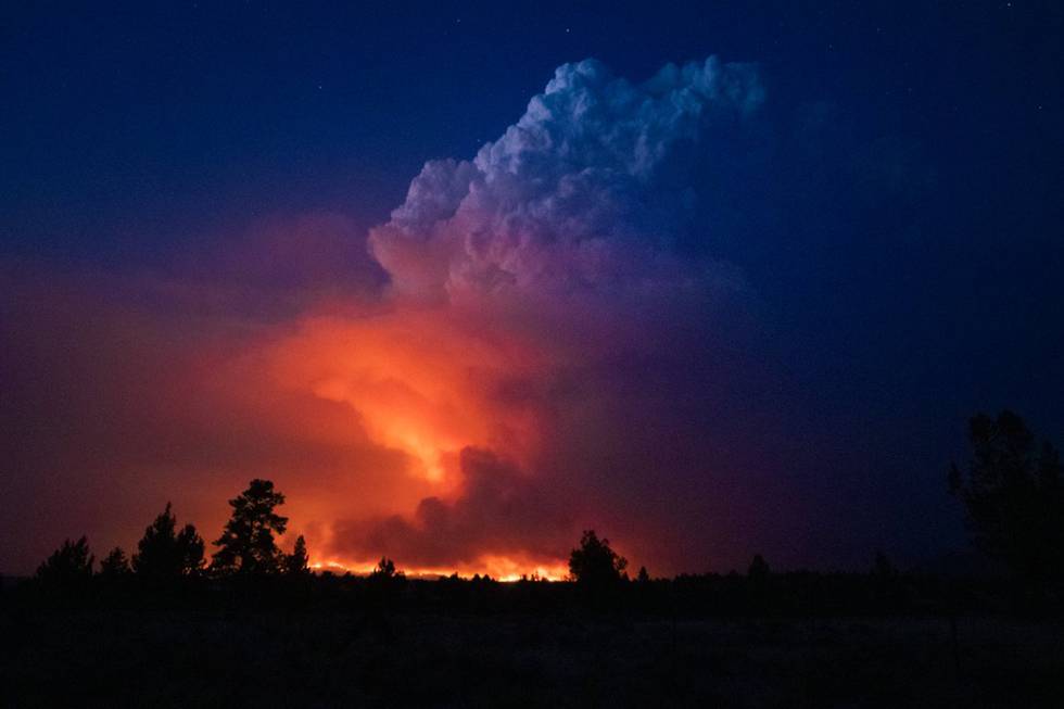 Bildet er av en skogbrann i USA. Røde flammer og grå røyk stiger fra bakken. Bildet er tatt i mørket på natta. Foto: Myndighetene i Oregon / AP / NTB