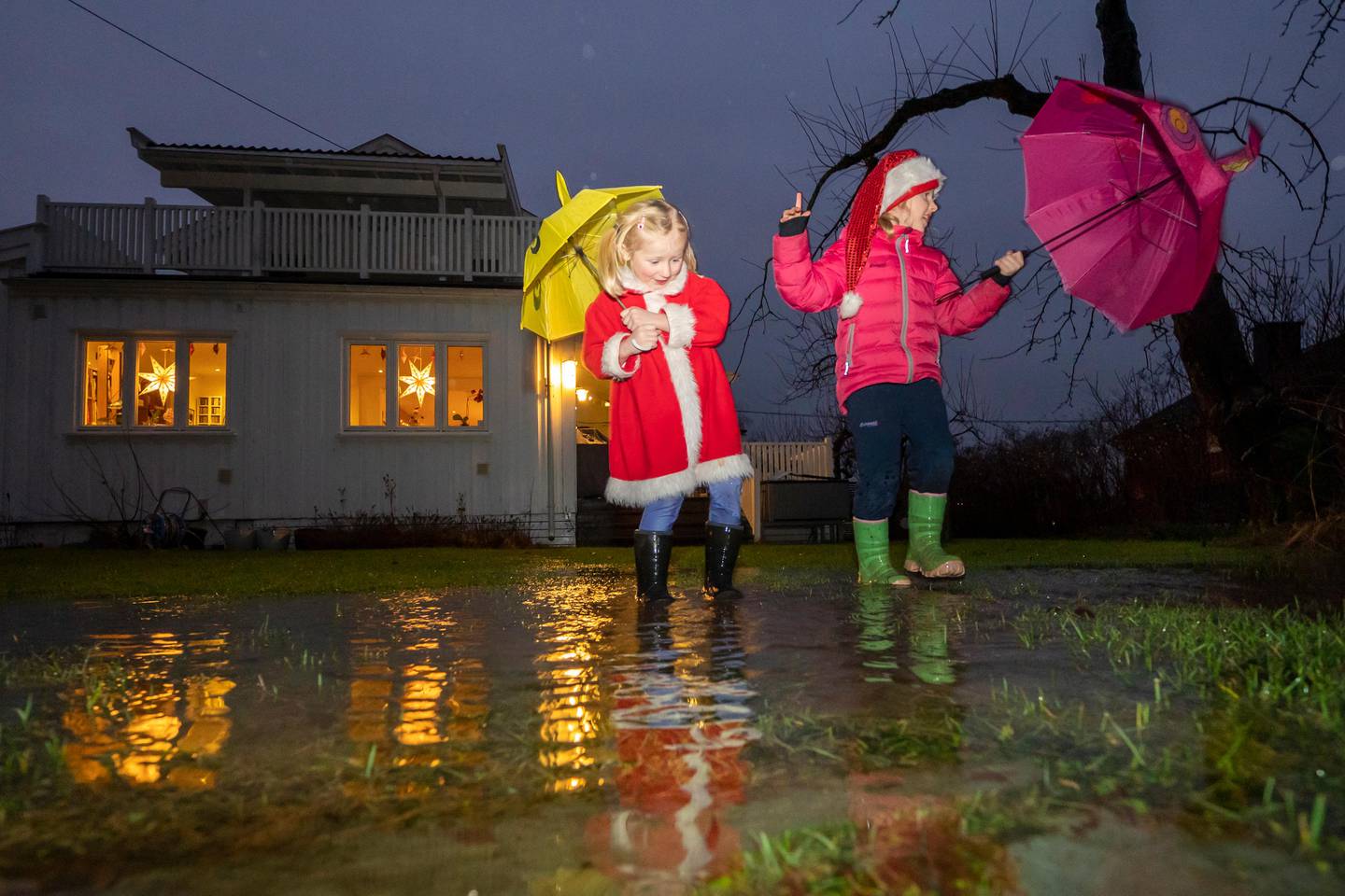 Oslo 20201215. 
Søstrene Maja (3) og Ida Åkerstrøm (5) leker i vannmassene i en oversvømt hage på Nordstrand i Oslo før jul. Det har kommet store mengde regn i hovedstaden i desember.
Foto: Heiko Junge / NTB