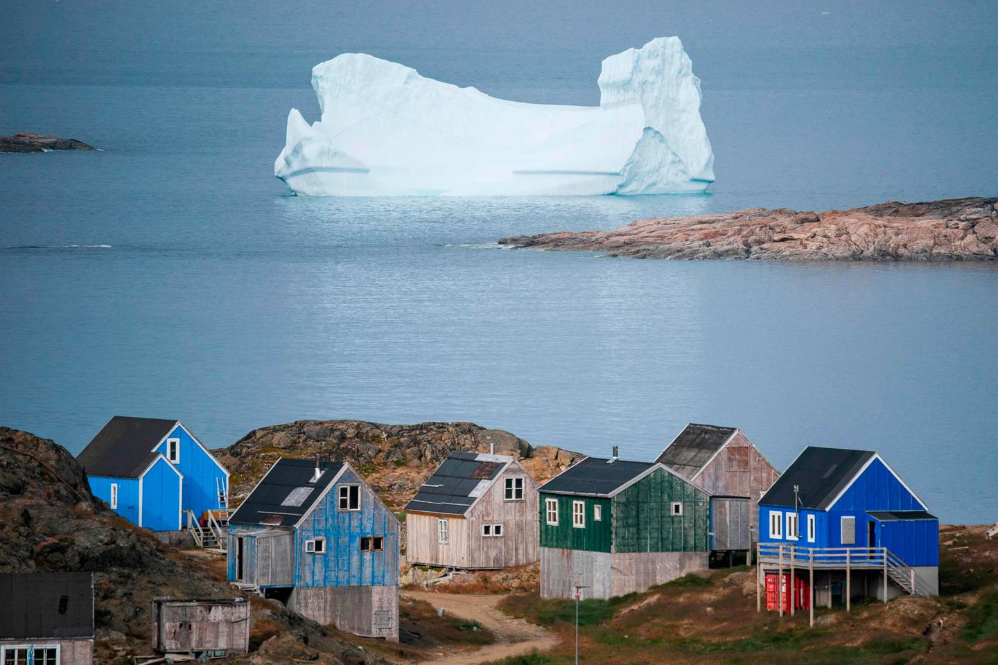 TOPSHOT - Icebergs float behind the town of Kulusuk in Greenland on August 19, 2019. - Denmark's prime minister said on August, 21, 2019 she was "annoyed and surprised" that US President Donald Trump postponed a visit after her government said its territory Greenland was not for sale, but insisted their ties remained strong. (Photo by Jonathan NACKSTRAND / AFP)