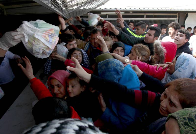 Flyktninger og migranter tar imot mat i leiren ved den makedonske landsbyen    Tabanovce ved grensen til Serbia. Siden Balkan-ruten stengte har mange blitt sittende fast i Makedonia. FOTO: BORIS GRDANOSKI/NTB SCANPIX