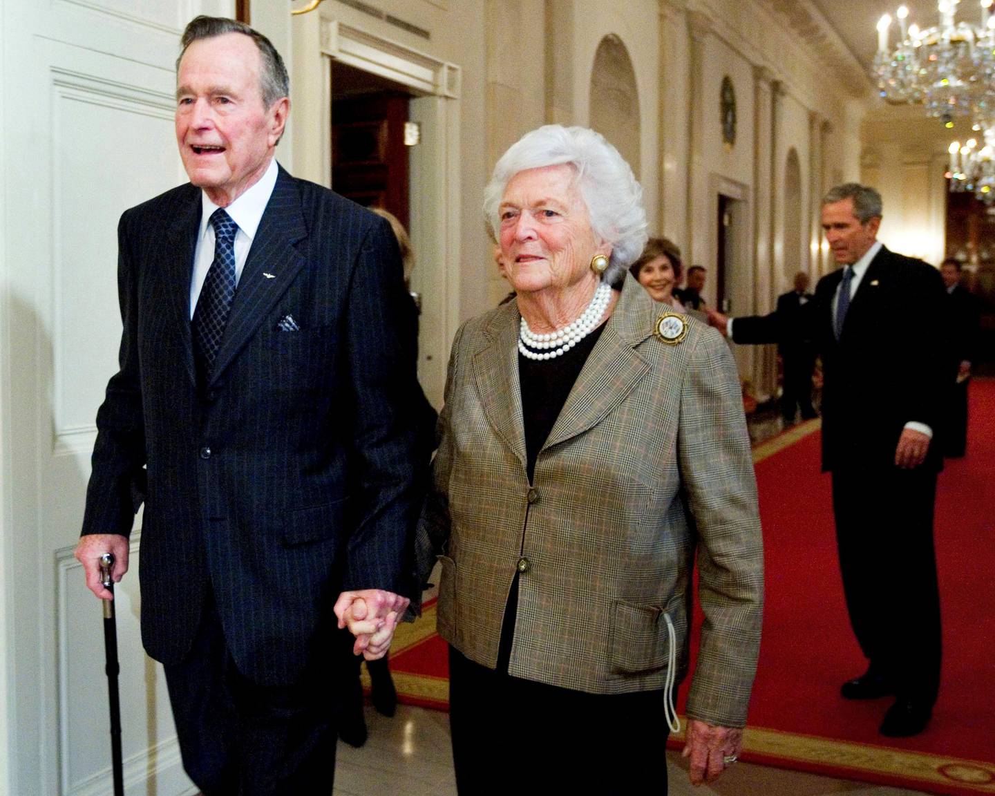 FILE - In this Jan. 7, 2009, file photo, former President George H. W. Bush, left, walks with his wife, former first lady Barbara Bush, followed by their son, President George W. Bush, and his wife first lady Laura Bush, to a reception in honor of the Points of Light Institute, in the East Room at the White House in Washington. Bush died at the age of 94 on Friday, Nov. 30, 2018, about eight months after the death of his wife, Barbara Bush. (AP Photo/Manuel Balce Ceneta, File)