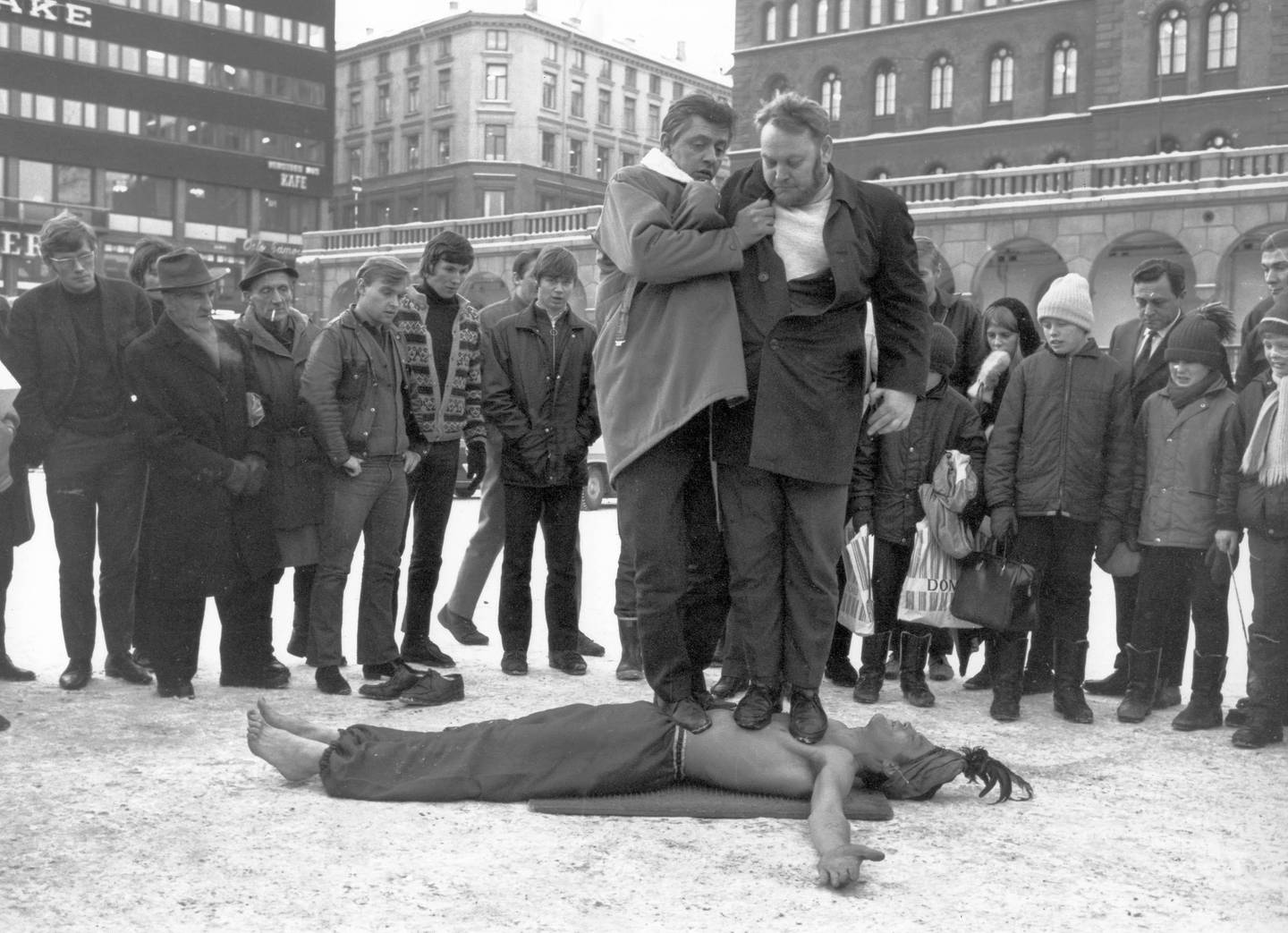 Oslo 06/02-1970.  Fakiren EL JUCAN (alias Einar Olsen) på Youngstorget. To menn står på brystkassen hans, mens han ligger på en spikermatte. Mannen t.h er forfatteren Sam O. Kjenne, han veier 104 kg.
Foto: Aktuell /  SCANPIX