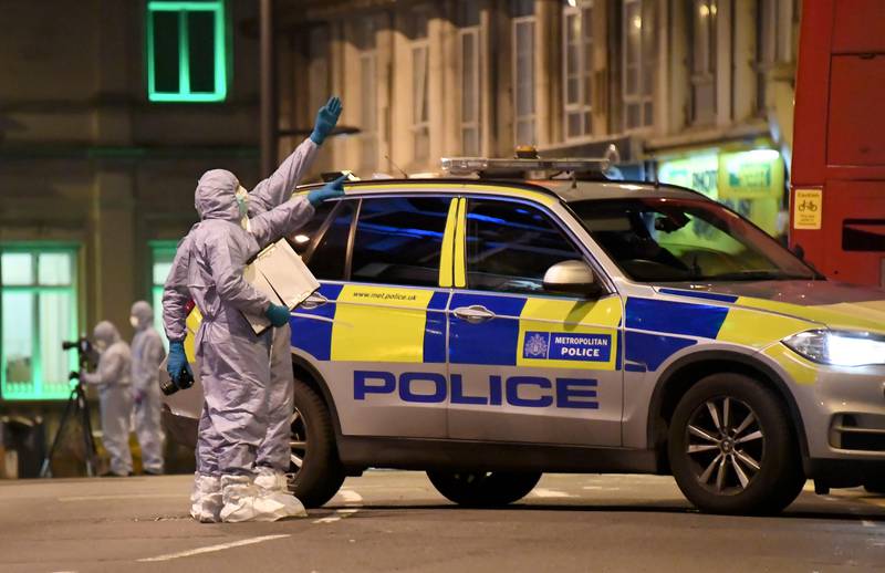 Police forensic officers work near the scene after a stabbing incident in Streatham London, England, Sunday, Feb. 2, 2020. London police officers shot and killed a suspect after at least two people were stabbed Sunday in what authorities are investigating as a terror attack. (AP Photo/Alberto Pezzali)