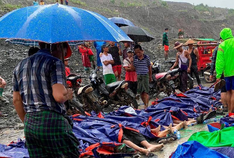 People gather near the bodies of victims of a landslide near a jade mining area in Hpakant, Kachine state, northern Myanmar Thursday, July 2, 2020. Myanmar government says a landslide at a jade mine has killed dozens of people.  (AP Photo/Zaw Moe Htet)