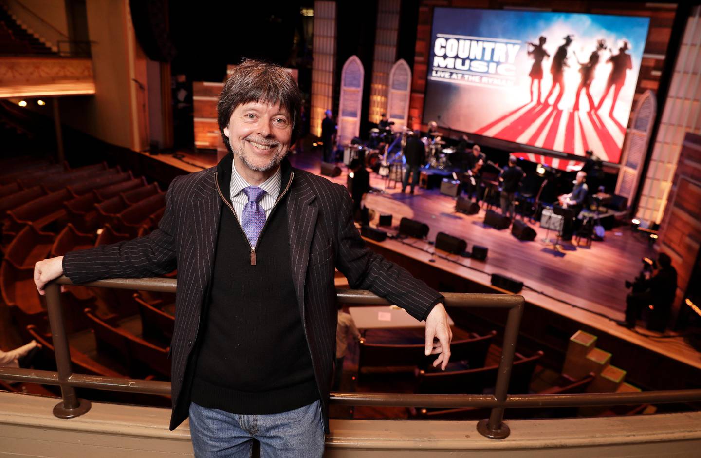 Filmmaker Ken Burn poses in the Ryman Auditorium Wednesday, March 27, 2019, in Nashville, Tenn. The Ryman was home to the Grand Ole Opry from 1943 to 1974. Burns hit the road this month on a bus trip to preach the gospel of "Country Music," his new PBS film airing in September. (AP Photo/Mark Humphrey)