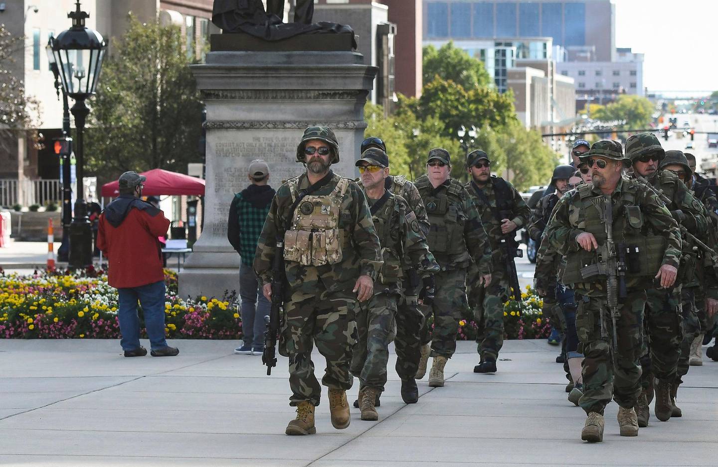 Michigan Home Guard militia members march toward the State Capitol to show their support for gun rights at the Second Amendment March at the State Capitol, Thursday, Sept. 17, 2020, in Lansing, Mich. Dozens gathered on the lawn of the Michigan Capitol to rally in support of their right to bear arms as well as to decry efforts undertaken by the state to rein in the coronavirus pandemic  efforts they say infringe upon their freedom. (Matthew Dae Smith/Lansing State Journal via AP)