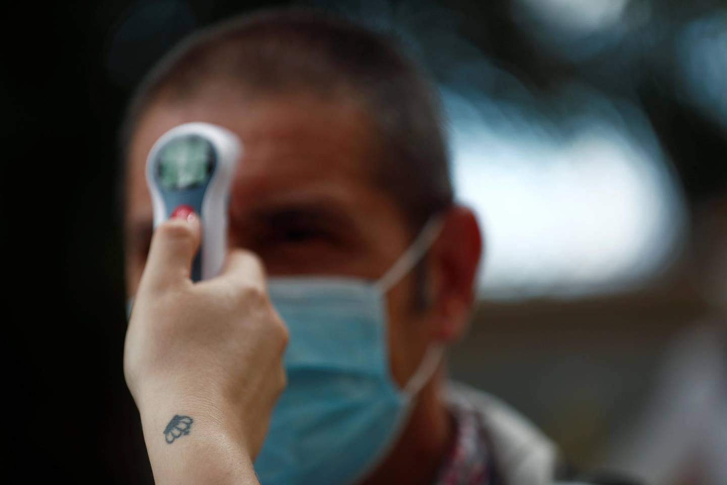 Social worker, Tamara Corona, checks the temperature of a visitor on the first day family visits are resumed after three months amid the coronavirus disease (COVID-19) outbreak at the nursing home Centro Casaverde in Navalcarnero, outside Madrid, Spain, June 8, 2020. REUTERS/Susana Vera