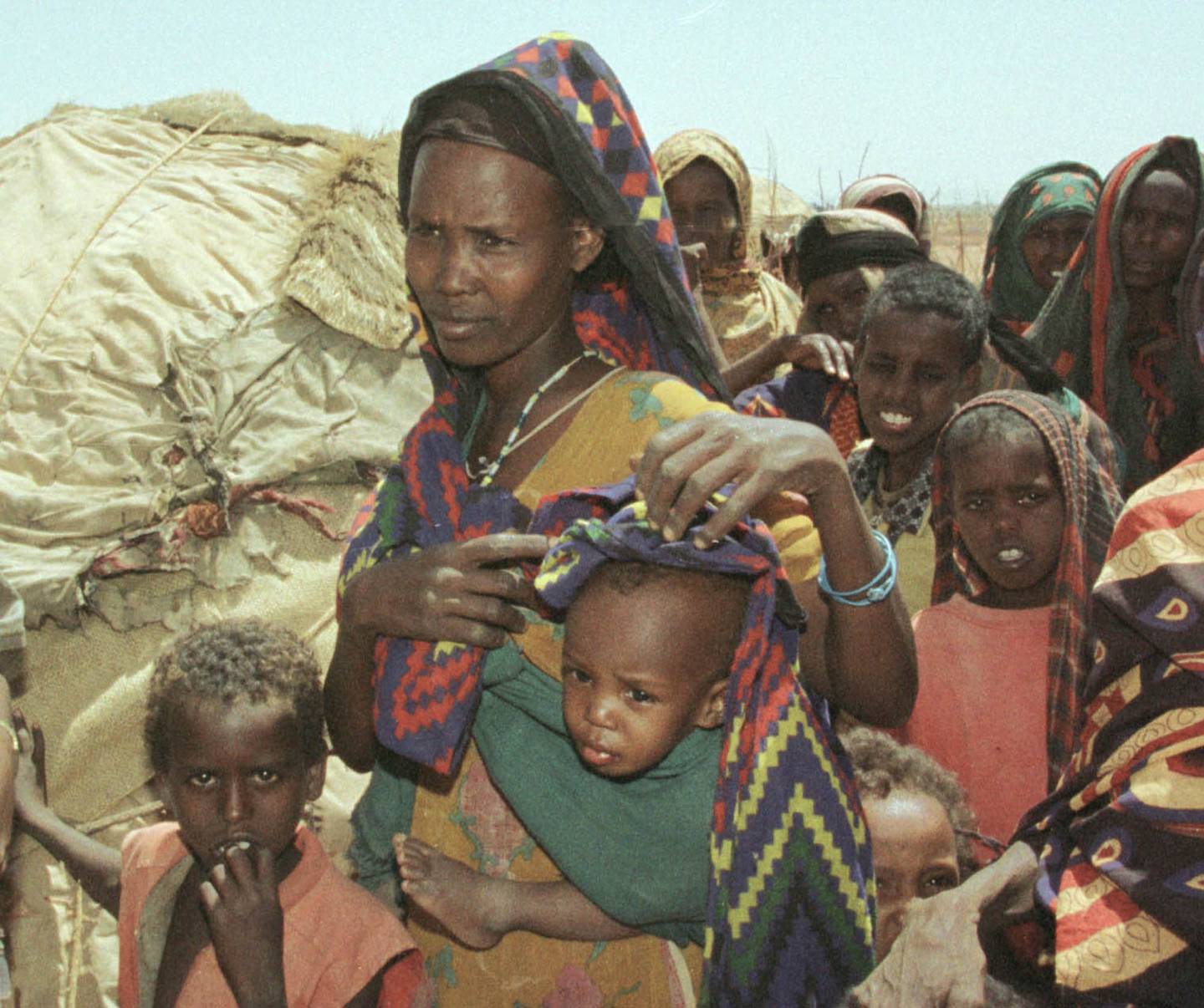 Adan Mohammed, second left, stands with her last surviving child after losing her four-year-old daughter and one-year-old son  while trekking for 10 days to a feeding center in Gode 580 kilometers (360 miles) southeast of the Ethiopian capital, Addis Ababa, Friday, March, 17, 2000. The 33-year-old mother began the desperate trip after losing her 200 cattle and sheep to the severe drought which in affecting the country.(AP PHOTOS/SAYYID AZIM)