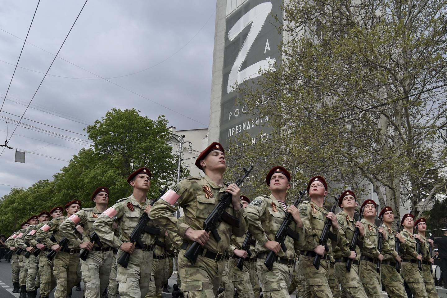 Russian National Guard (Rosguardia) servicemen march through a street with a letter Z, which has become a symbol of the Russian military on a building in Sevastopol, Crimea, Thursday, May 5, 2022.  (AP Photo)