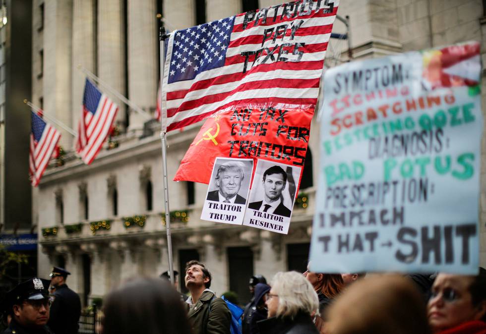 PROTESTER: Demonstranter protesterte mot skattereformen i New York søndag, med plakater av president Trump og hans svigersønn Jared Kushner. FOTO: EDUARDO MUNOZ/NTB SCANPIX