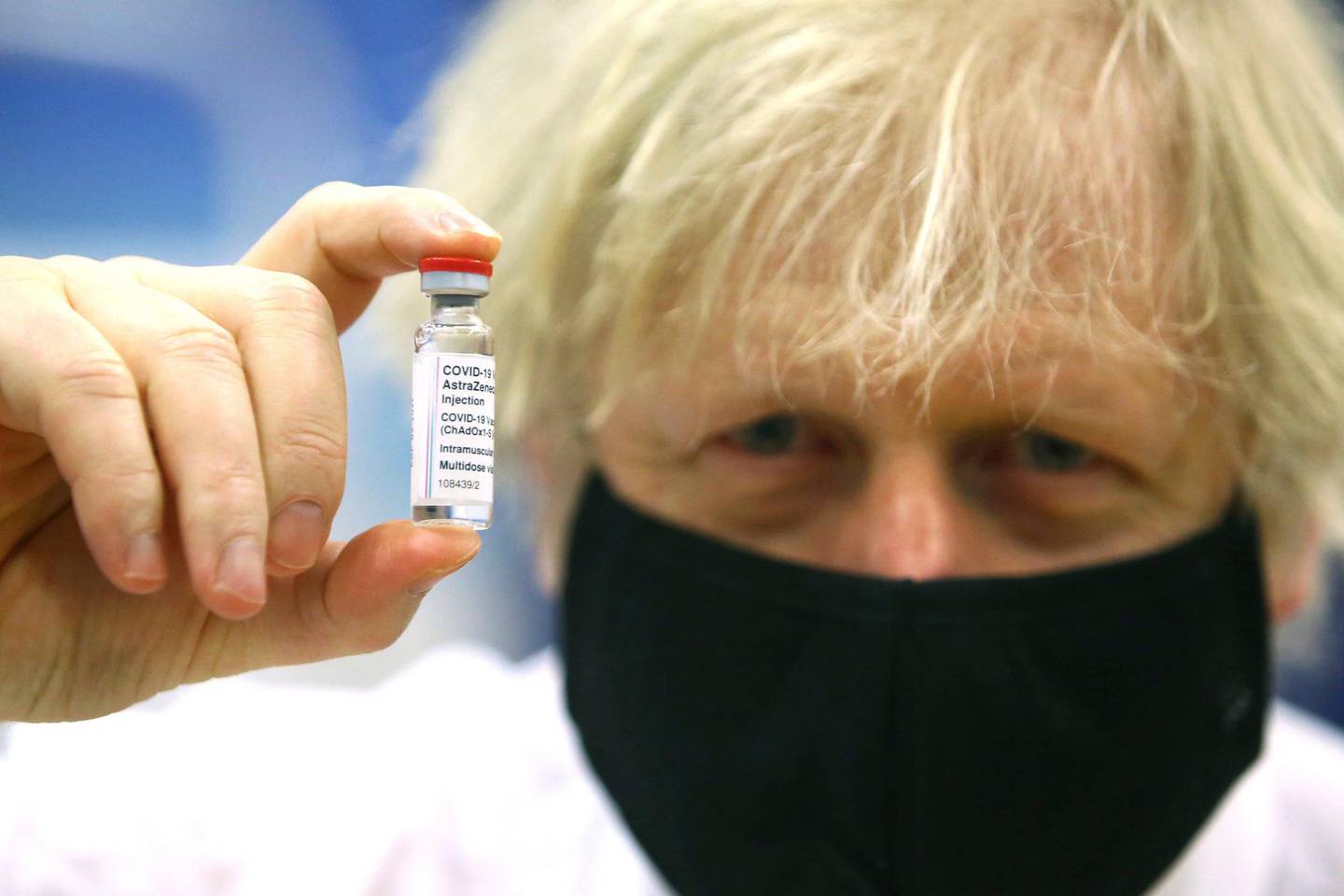 FILE - In this Wednesday, Feb. 17, 2021 file photo, Britain's Prime Minister Boris Johnson holds a vial of the Oxford/Astra Zeneca Covid-19 vaccine at a vaccination centre in Cwmbran, south Wales. The British government says it aims to give every adult in the country a first dose of coronavirus vaccine by July 31, a month earlier than its previous target. In addition, the goal is for everyone over 50 or with an underlying health condition to get a shot by April 15, rather than the previous target of May 1.  (Geoff Caddick/Pool via AP, File)
