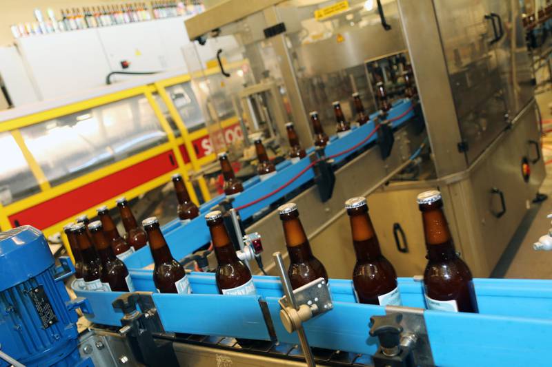 Rundt 5000 flasker Lucky Jack produseres i timen på bryggeriet i Hillevåg når maskineriet går for fullt, her er et knippe på vei gjennom linjen. Foto: Thor Erik Waage 