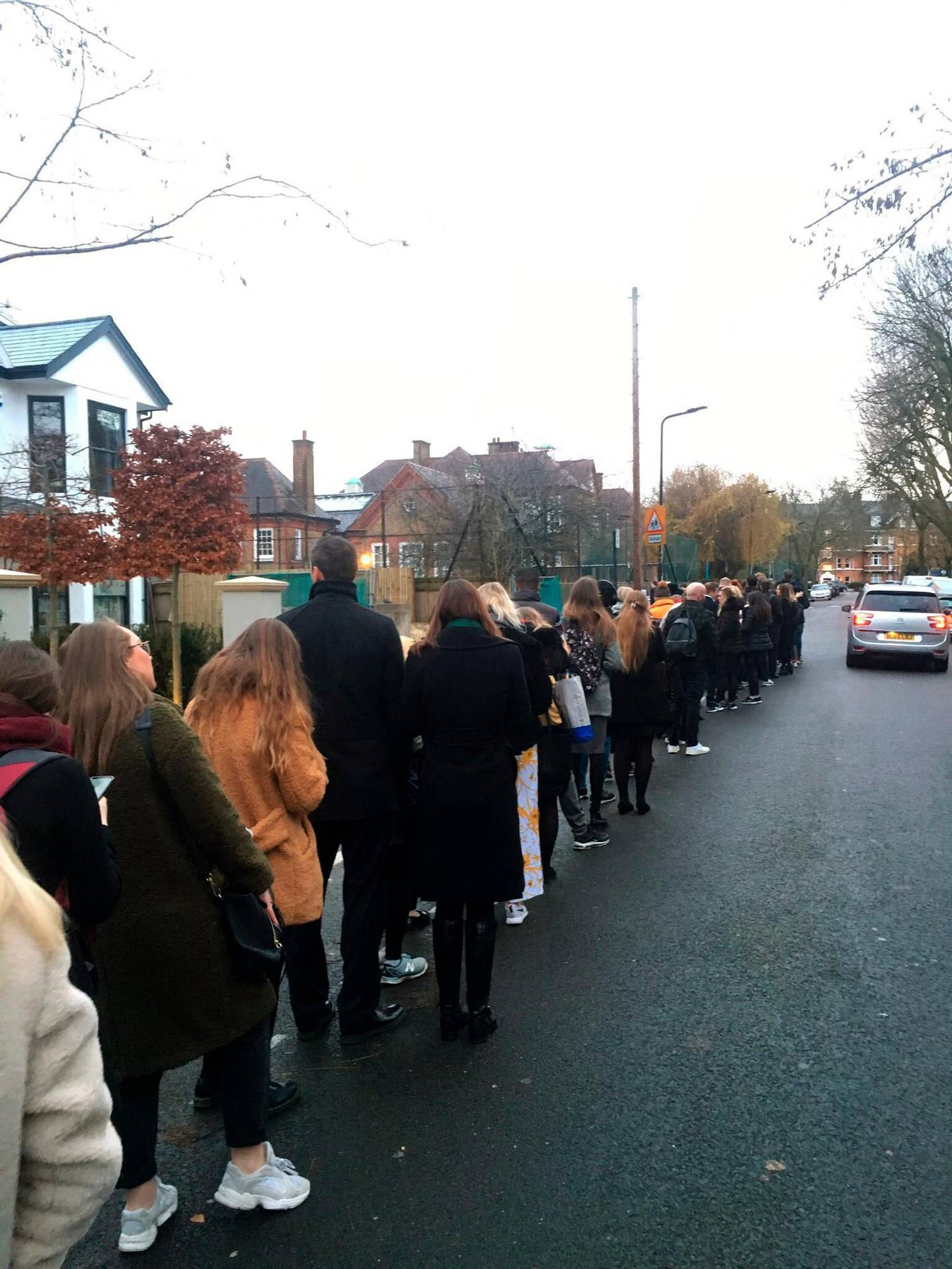 In this photo made available by Kelly Molloy, people queue to cast their ballots, at polling station, during the general election, in Clapham, London, Thursday, Dec. 12, 2019. Britain is holding an early election in wintry December, with a number of strange locations put in use as polling places. Among the places where Britons cast their ballots Tuesday were a car dealership, a laundrette, a Christmas grotto and of course some pubs. There were a few problems, including flooding at one location. (Kelly Molloy via AP)