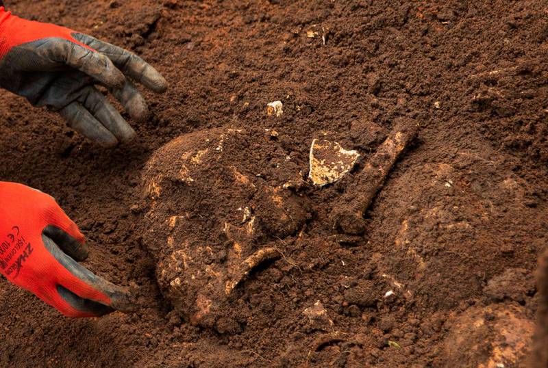 A Burundian worker from the Truth and Reconciliation Commission extracts the skull of an unidentified person from a mass grave in the Bukirasazi hill in Karusi Province, Burundi January 27, 2020. Picture taken January 27, 2020. REUTERS/Evrard Ngendakumana