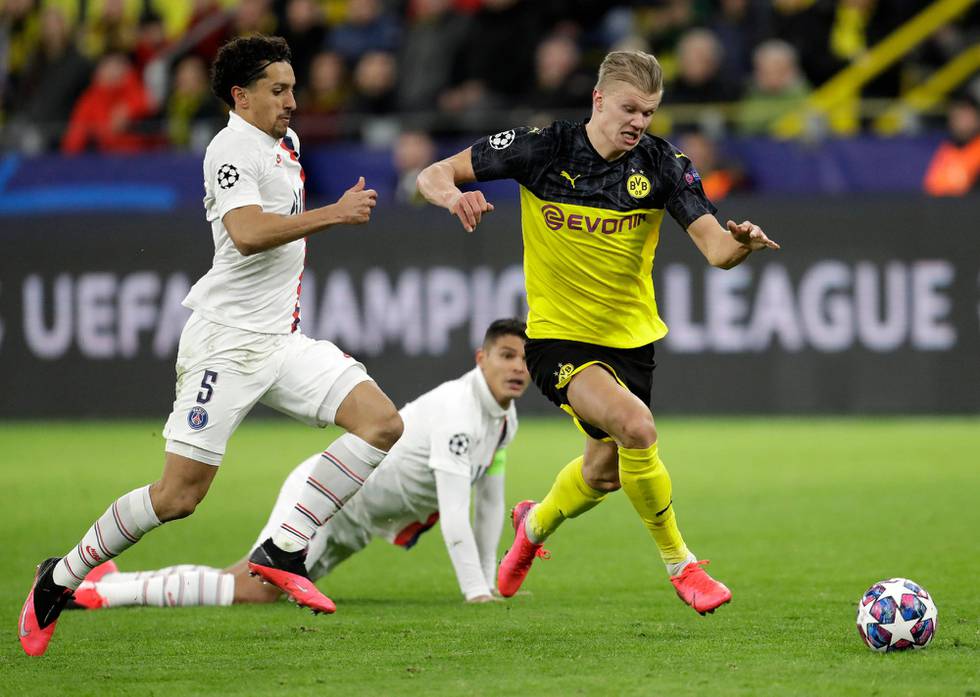 Dortmund's Erling Braut Haaland, right, and PSG's Marquinhos run for the ball during the Champions League round of 16 first leg soccer match between Borussia Dortmund and Paris Saint Germain in Dortmund, Germany, Tuesday, Feb. 18, 2020. (AP Photo/Michael Probst)