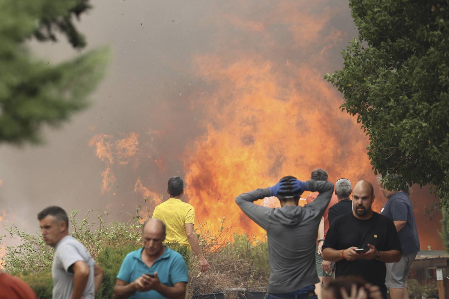 Beboere betrakter brannen ved byen Añón de Moncayo i Aragón, 70 kilometer vest for Zaragoza. Den blusset kraftig opp natt til søndag, og byens innbyggere måtte evakueres. Foto: Fabian Simon / Europa Press via AP / NTB