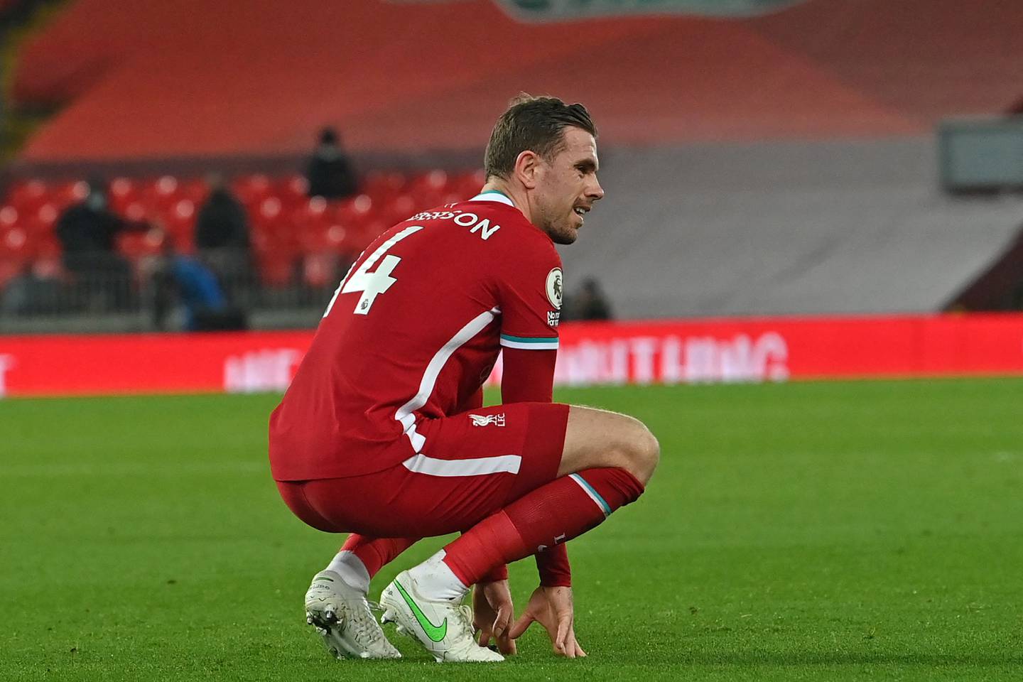 Liverpool's English midfielder Jordan Henderson reacts after picking up an injury during the English Premier League football match between Liverpool and Everton at Anfield in Liverpool, north west England on February 20, 2021. (Photo by Paul ELLIS / POOL / AFP) / RESTRICTED TO EDITORIAL USE. No use with unauthorized audio, video, data, fixture lists, club/league logos or 'live' services. Online in-match use limited to 120 images. An additional 40 images may be used in extra time. No video emulation. Social media in-match use limited to 120 images. An additional 40 images may be used in extra time. No use in betting publications, games or single club/league/player publications. /