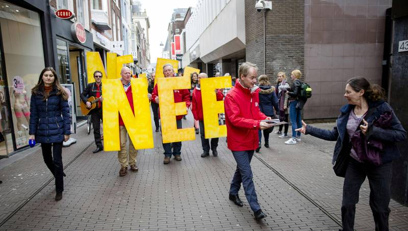 Medlem av det nederlandske sosialistpartiet Harry van Bommel deler ut flyere som oppfordrer til å stemme nei i folkeavstemningen som ble avholdt onsdag. Et overveldende flertall av dem som deltok, sa nei. FOTO: BART MAAT / NTB SCANPIX