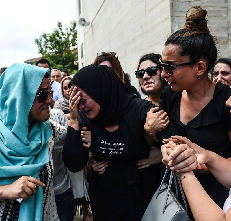 En kvinne gråter i begravelsen til sin far, Siddik Turgan, som ble drept i angrepet mot flyplassen i Istanbul i Tyrkia mandag.