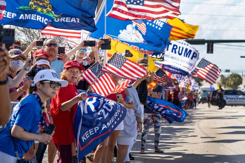 Supporters wait for former President Donald Trump to go by in West Palm Beach, Fla., Monday, Feb. 15, 2021. People lined the street on President's Day to show support for Trump who lost the 2020 election to President Joe Biden. (Greg Lovett/The Palm Beach Post via AP)