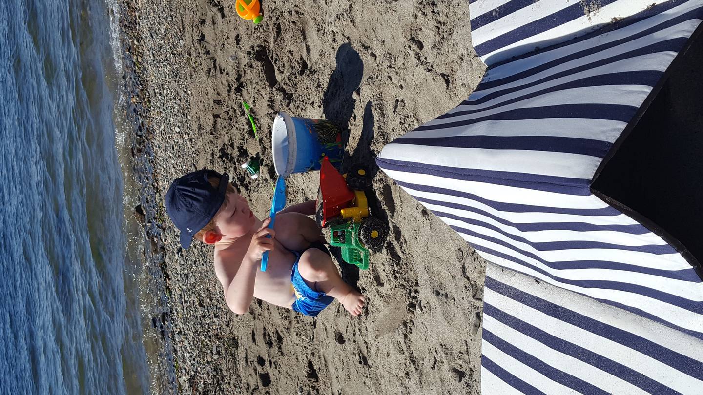 Vilmer koser seg på stranda en deilig sommerdag ... så nært, med sand mellom tærne – ivrig opptatt av å flytte sand fra bøtte til lastebil (og tilbake igjen). Sommerlykke!