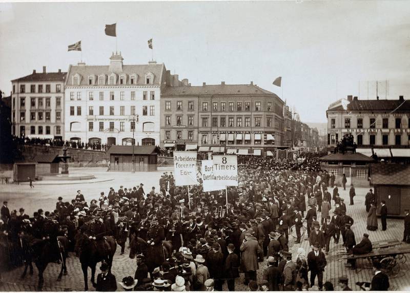 1. mai-toget på Youngstorget i 1908 med parolene «8  Timers arbeidsdag», «Arbeidere, forener Eder», «Bort med alt Overtidsarbeid».