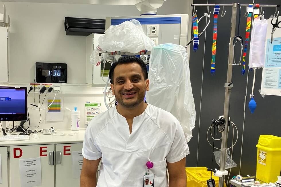 Adeel Anwar i hvit legeskjorte i et rom på sykehuset