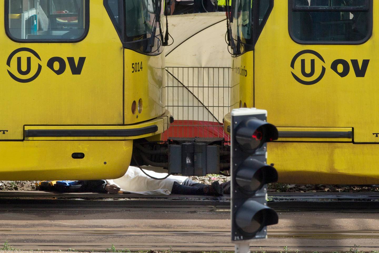 A body is covered with a blanket next to a tram following a shooting in Utrecht, Netherlands, Monday, March 18, 2019. Police in the central Dutch city of Utrecht say on Twitter that "multiple" people have been injured as a result of a shooting in a tram in a residential neighborhood. (AP Photo/Peter Dejong)
