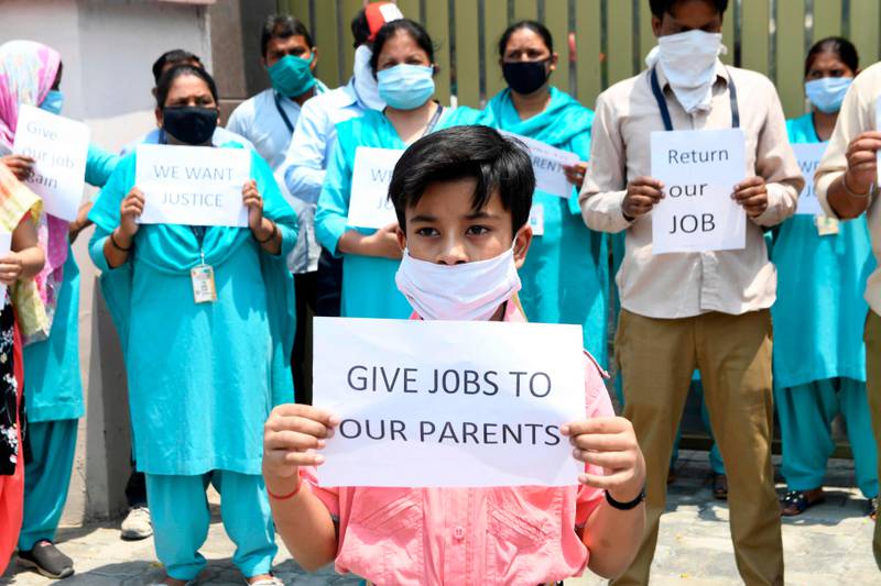 Employees who were sacked by DAV Public school hold placards demanding their jobs back after the government eased a nationwide lockdown imposed as a preventive measure against the COVID-19 coronavirus, in Amritsar on June 5, 2020. (Photo by NARINDER NANU / AFP)