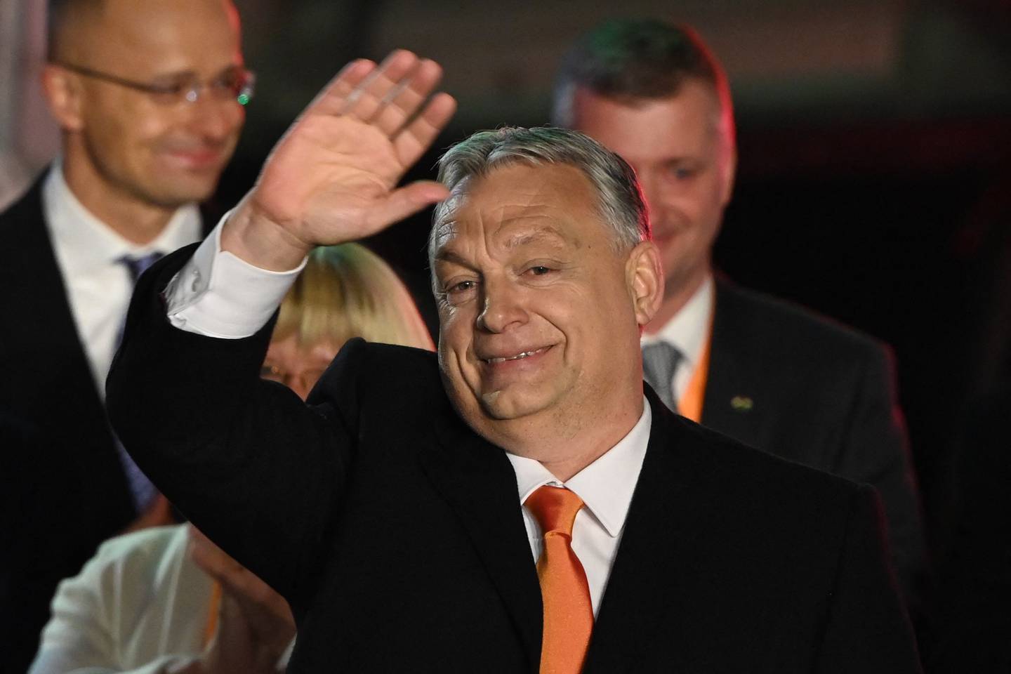 (FILES) Hungarian Prime Minister Viktor Orban and members of the Fidesz party celebrate on stage at their election base, 'Balna' building on the bank of the Danube River of Budapest, on April 3, 2022, after Orban claimed a 'great victory' in the general election, as partial results gave his Fidesz party the lead. The results of the recent elections in Poland could have given a glimmer of hope for Hungarians longing for a change. Both European Union member states were widely accused of sliding into authoritarianism, and observers criticised them for having free, but not fair elections. Yet, the ideologically diverse Polish pro-EU parties have managed to triumph at the polls in late October. (Photo by Attila KISBENEDEK / AFP)