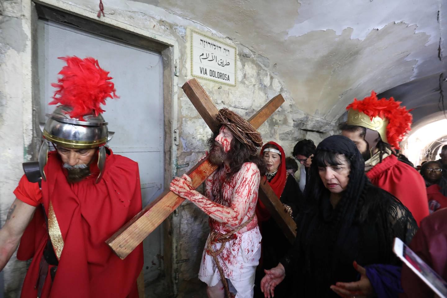 En katolsk pilgrim utkledd som Jesus bærer et kors langs Via Dolorosa («lidelsesveien») i Gamlebyen i Jerusalem, som en del av påskefeiringen i byen i 2019.