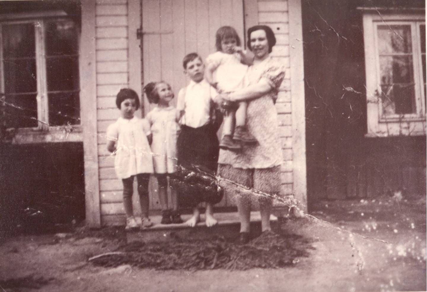 Ludvig Karlsen (i midten) med sin familie står oppstilt utenfor huset