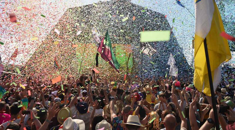 (FILES) In this file photo taken on June 30, 2019 Revellers cheer as Australian singer Kylie performs at the Glastonbury Festival of Music and Performing Arts on Worthy Farm near the village of Pilton in Somerset, South West England. - The Glastonbury music festival, due to celebrate its 50th anniversary this year, announced on March 18, 2020, it would be postponed until 2021 due to the ongoing coronavirus pandemic. (Photo by Oli SCARFF / AFP)