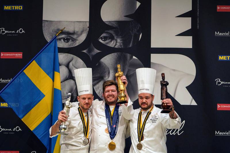 Kenneth Toft-Hansen of Denmark, center, celebrates on the podium after winning the final of the "Bocuse d'Or" (Golden Bocuse) trophy, in Lyon, central France, ahead Sebastian Gibrand of Sweden, left, who finished second, and Christian Andre Pettersen of Norway, right, who came third, Wednesday, Jan. 30, 2019. The contest, a sort of world cup of cuisine, was started in 1987 by Lyon chef Paul Bocuse to reward young international culinary talents. (AP Photo/Laurent Cipriani)