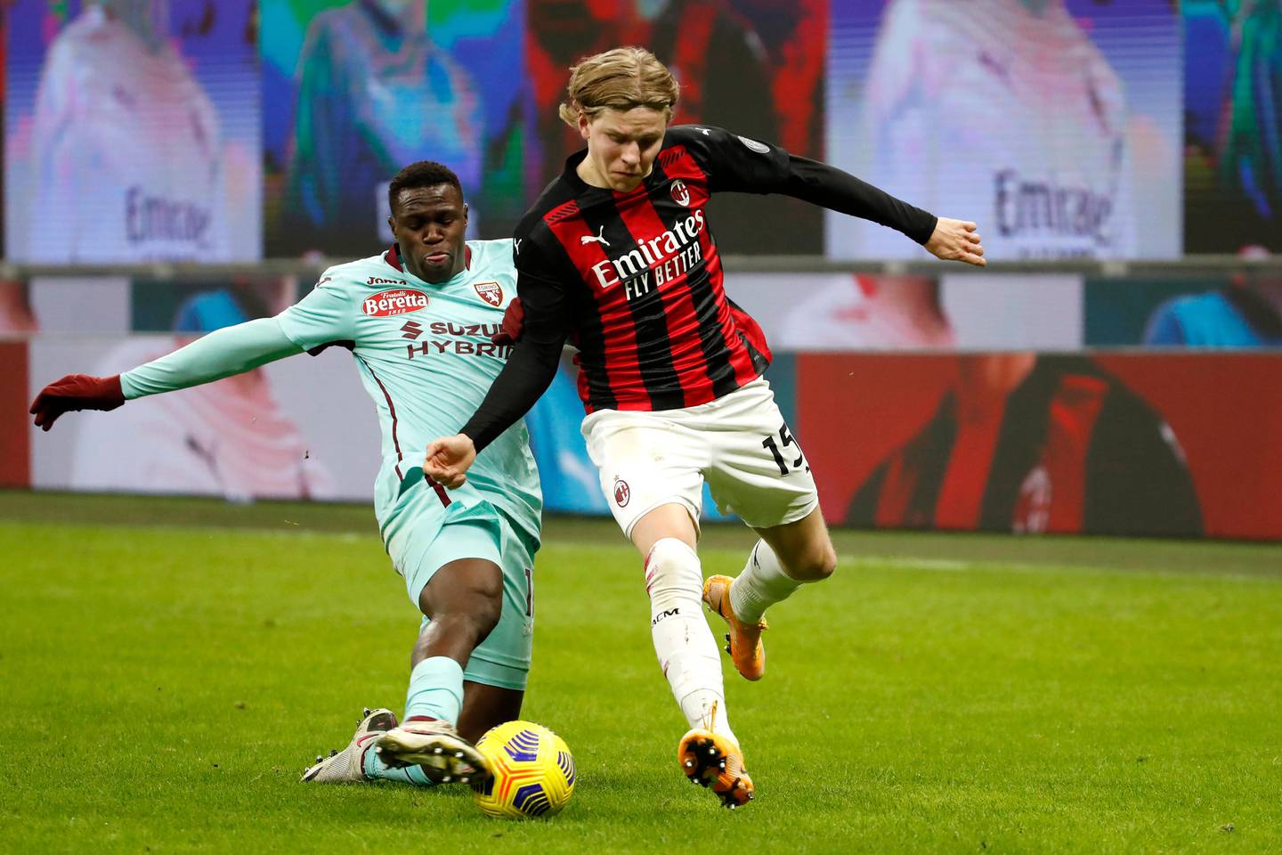 Torino's Wilfried Singo, left, fights for the ball with AC Milan's Jens Petter Hauge during the Serie A soccer match between AC Milan and Torino at the San Siro stadium in Milan, Italy, Saturday, Jan. 9, 2021. (AP Photo/Antonio Calanni)