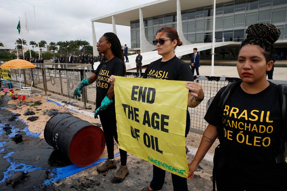Greenpeace activists protest against the government's environmental policies, in front of the Planalto Presidential Palace, in Brasilia, Brazil, Wednesday, Oct. 23, 2019. Greenpeace denounced what they call the government's neglect of environmental issues and slowness to solve problems like the oil spill in the northeast and fires in the Amazon. (AP Photo/Eraldo Peres)