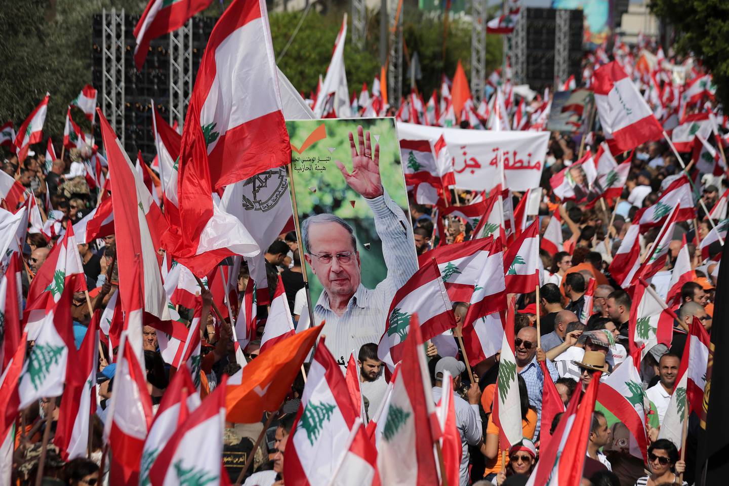 Supporters of Lebanese President Michel Aoun carry pictures of him and Lebanese flags during a protest near the presidential palace in the Beirut suburb of Baabda, Lebanon, Sunday, Nov. 3, 2019. Thousands of people are marching to show their support for Aoun and his proposed political reforms that come after more than two weeks of widespread anti-government demonstrations. (AP Photo/Hassan Ammar)